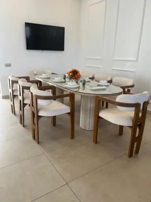 a dining room with a table and chairs and a television at Villa luxe kech in Marrakech