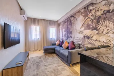 a living room with a couch and a wall mural at Brand New and Stylish appart hotel Best location in Marrakech