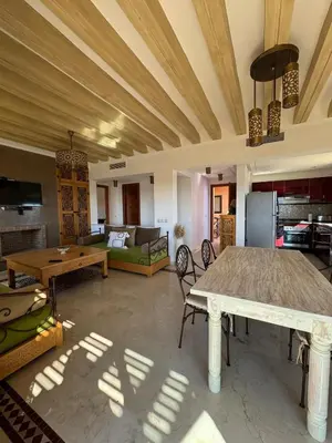 a living room with a table and a couch at Cosy Appartement Avec Piscine, Terrain tennis et loisirs in Marrakech