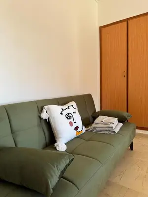 a couch with a pillow with a face on it at Cosy Appartement Avec Piscine, Terrain tennis et loisirs in Marrakech