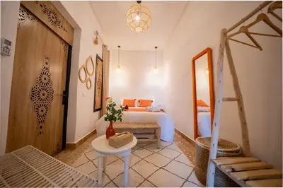 a bedroom with a bed and a table and a mirror at Riad Le Soleil de Bahia in Marrakech