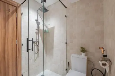 a bathroom with a glass shower with a toilet at Bel Appartement Vue Piscine in Marrakech