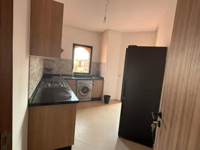 a kitchen with a black refrigerator and a stove at Bel Appartement Vue Piscine in Marrakech