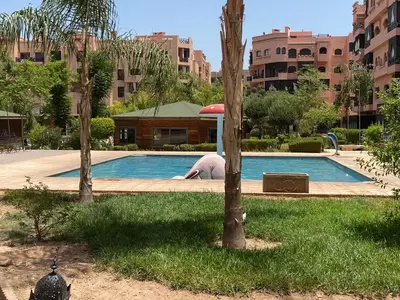 a man laying on the ground next to a swimming pool at Bel Appartement Vue Piscine in Marrakech