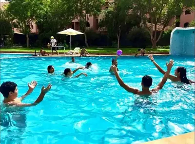 a group of people playing frisbee in a swimming pool at Bel Appartement Vue Piscine in Marrakech