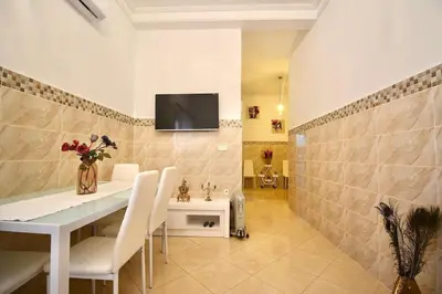 a dining room with a table and a tv on a wall at Gold Holidays 02 in Marrakech