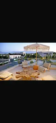 a group of lounge chairs and an umbrella on a beach at Villa coco in Marrakech