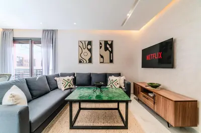 a living room with a blue couch and a table at Charming Apartment in Hyper Center Modernity in Marrakech
