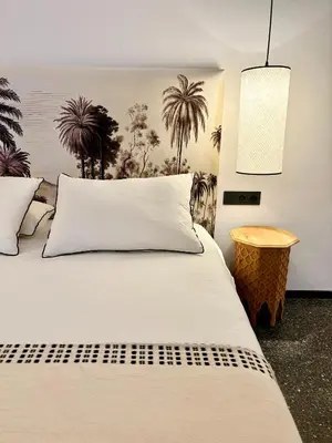 a bedroom with a bed with white sheets and palm trees at Palais Celeste in Marrakech