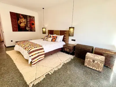 a bedroom with a bed and a painting on the wall at Palais Celeste in Marrakech