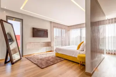 a bedroom with a bed and a tv on a wall at Villa located at Argan Golf Resort Prestigia in Marrakech