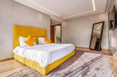 a bedroom with a large bed and a large mirror at Villa located at Argan Golf Resort Prestigia in Marrakech