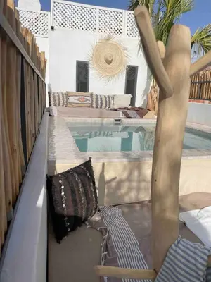 a balcony with a chair next to a swimming pool at Riad en exclusivité Maison Habibi in Marrakech