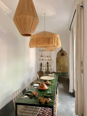 a dining room with a green table and chairs at Riad en exclusivité Maison Habibi in Marrakech