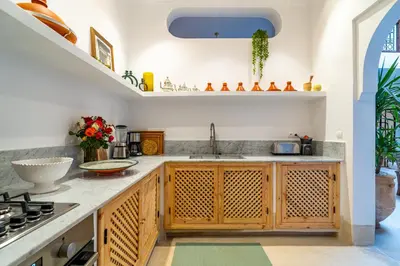 a kitchen with wooden cabinets and a sink at Riad Sofia Marrakech in Marrakech