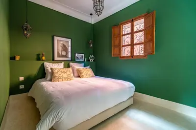 a bedroom with green walls and a white bed at Riad Sofia Marrakech in Marrakech