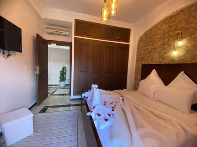 a bedroom with a large bed with a tv at Warda 2 Bedroom Hivernage Apartment in Marrakech