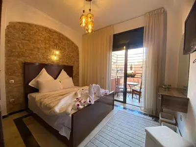 a bedroom with a large bed and a balcony at Warda 2 Bedroom Hivernage Apartment in Marrakech