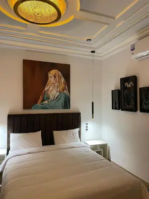 a bedroom with a bed with a painting on the wall at Riad Casa Maria in Marrakech