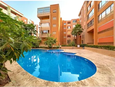 a large blue swimming pool in front of a building at Luxueux Appartement Avec piscine in Marrakech