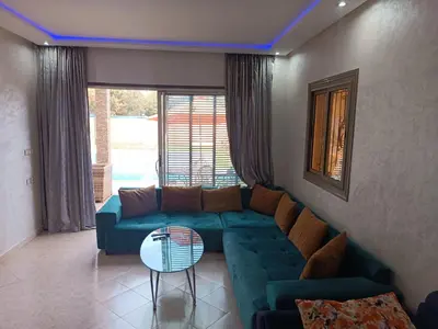 a living room with a blue couch and a table at villa paradisiaque in Marrakech