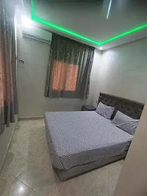 a bed in a room with a green light at villa paradisiaque in Marrakech