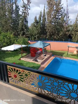 a pool on a deck with a fence and a table at villa paradisiaque in Marrakech