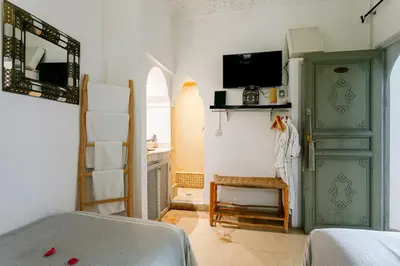 a bedroom with a bed and a tv on a wall at Riad LOU, 5 bedrooms, private 12 p, pool, hammam in Marrakech