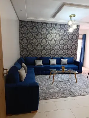 a living room with a blue couch and a table at Magnifique studio douillet in Marrakech