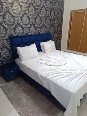 a large bed with a blue headboard in a bedroom at Magnifique studio douillet in Marrakech