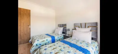 a bedroom with two beds and a wooden door at Nor in Marrakech