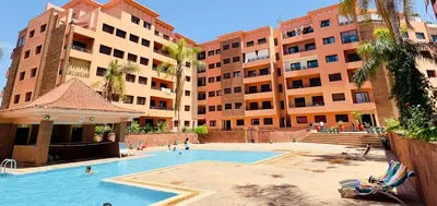 a swimming pool in front of some tall buildings at Résidence Babylone Y - Appartement 2 Chambres in Marrakech