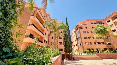 a row of buildings with palm trees in front of them at - Résidence Babylone Y - 3 Bedrooms Appartement in Marrakech