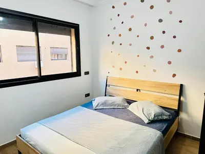 a small bedroom with a bed and a window at Gueliz flat centre in Marrakech