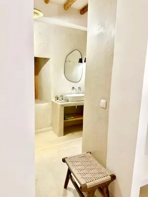 a bathroom with a sink and a mirror and a stool at Riad Fleur de Kasbah in Marrakech
