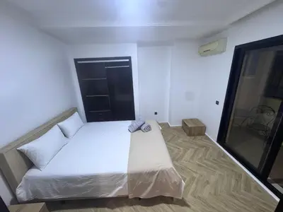 a bedroom with a white bed and a window at New Résidence Miramas 2 in Marrakech