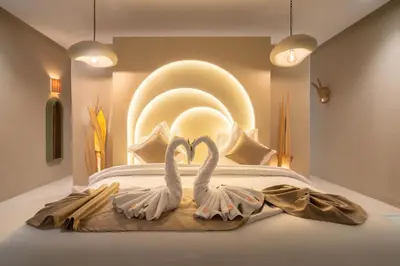 two white swans are sitting on a bed at Villa Bali Amelkis in Marrakech