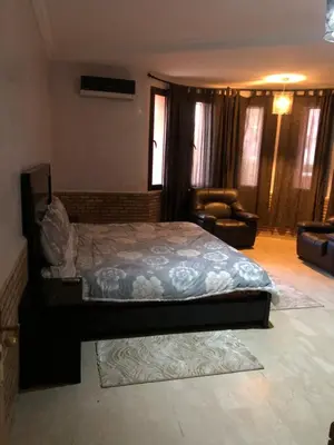 a bedroom with a bed and a chair in it at - Résidence Babylone Y - Appartement 3 Chambres in Marrakech
