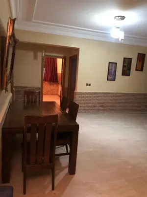 a dining room with a wooden table and chairs at - Résidence Babylone Y - Appartement 3 Chambres in Marrakech