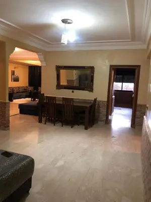 a living room with a table and a couch at - Résidence Babylone Y - Appartement 3 Chambres in Marrakech