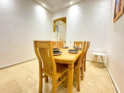 a dining room with a wooden table and chairs at Elegant 2-Bedroom Duplex Downtown Private Terrace in Marrakech
