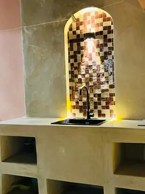 a kitchen counter with a sink and a mirror at Évasion aux portes de Majorelle in Marrakech