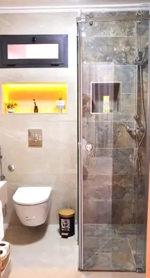 a bathroom with a toilet and a glass shower at Darraha- Ideal for early & Late flights-Near Marrakech airport 10 min- menara Garden 5 min-Transport support in Marrakech