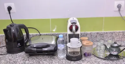 a kitchen counter with a toaster a coffee maker and water bottles at Darraha- Ideal for early & Late flights-Near Marrakech airport 10 min- menara Garden 5 min-Transport support in Marrakech