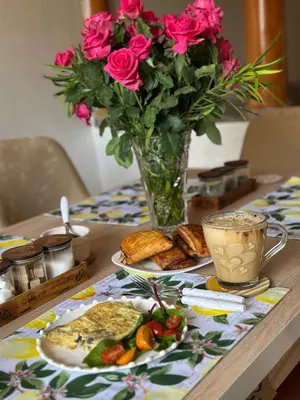 a table with a vase of roses and a plate of food at Ghazaly house in Marrakech