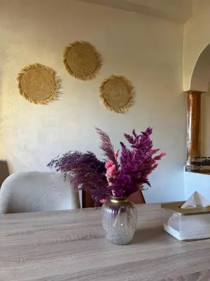 a vase with purple flowers sitting on a table at Ghazaly house in Marrakech