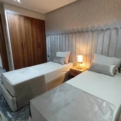 a hotel room with two beds and a lamp on a table at Modern 2-Bedroom Family Flat in Central Marrakech in Marrakech