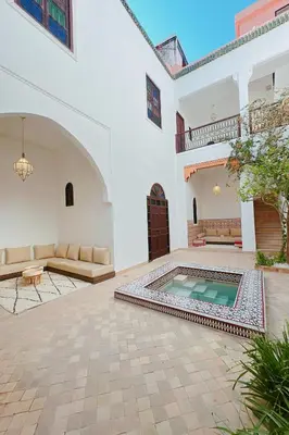 a courtyard with a swimming pool in a building at Riad Solila, Fabuleux riad avec 4 Suites, Piscine Chauffée et Rooftop - 5 min de Jamaa El Fna in Marrakech