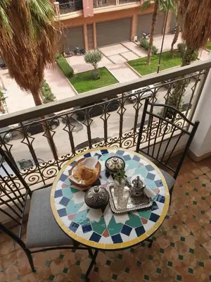 a table with a plate of food on a balcony at In Gueliz, Chic and Ethnic with a palm view in Marrakech