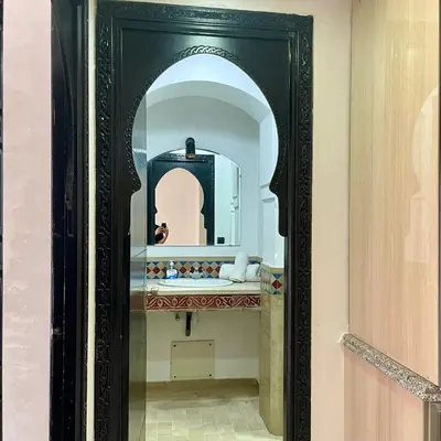 a bathroom with a mirror in a black frame at In Gueliz, Chic and Ethnic with a palm view in Marrakech